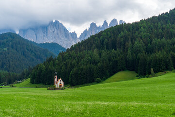 Fototapeta na wymiar Romantic church built on colourful meadow in the Italian Dolomites.