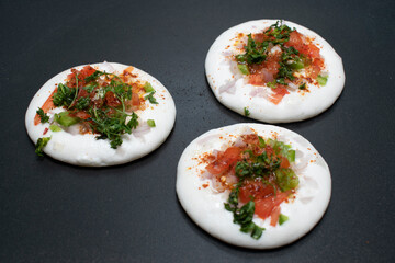 adding coriander leaves on freshly baked utappam on hot non stick tawa or pan