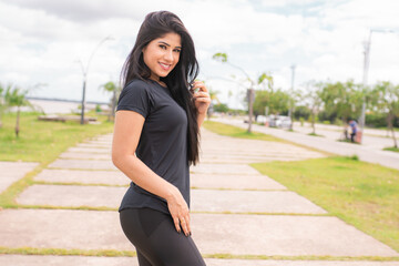 Fototapeta premium Mulher jovem e bonita posando para a câmera depois da corrida.