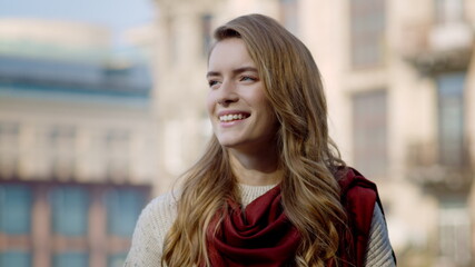 Smiling woman standing outdoors. Pretty girl enjoying sunny day outside