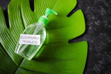 environmental awareness concept, Sustainable Products label on cleaning product with tropical leaf on dark background