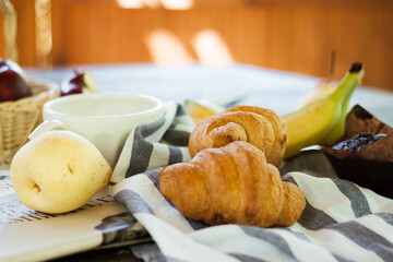 fresh fruit and croissants on the wooden table