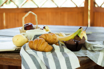 fresh fruit and croissants on the wooden table