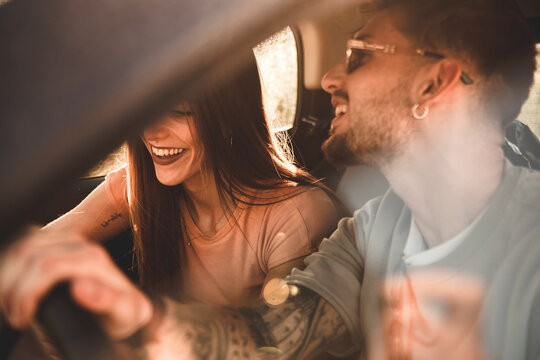 Dettaglio di lei e lui sorridenti mentre sono in viaggio con la loro auto durante una vacanza estiva