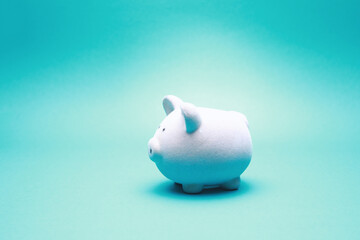 Small toy piggy bank look at camera isolated on green background with copy space