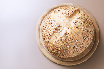 Fresh homemade bread with seeds and rosemary on wooden cutting board with copy space