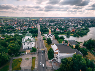 Aerial view of two old churches near river and bridge in small european city