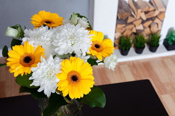 bouquet of chrysanthemums on a dark table near a white fireplace