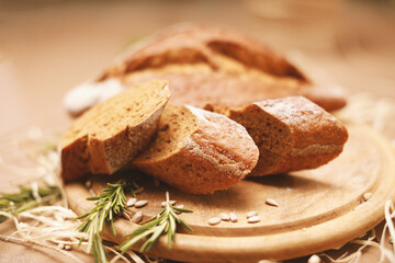 Fototapeta na wymiar Sliced homemade bread with rosemary on wooden cutting board 