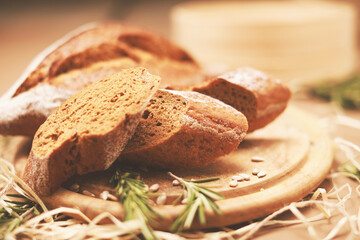 Sliced homemade bread with rosemary on wooden cutting board 