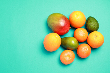 Fresh mix of tropical fruits. Mango, oranges and avocado isolated on gray background with copy space
