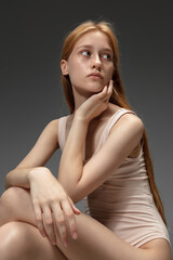 Fototapeta premium New look. Fashion portrait of beautiful redhead woman isolated on grey studio background. Concept of beauty, skin care, fashion and style. Artwork, modern and trendy portrait. Attractive model.