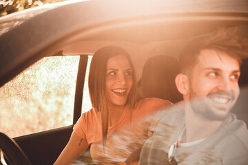 Coppia di fidanzati guarda fuori dal finestrino della loro auto con spontaneità mentre sono in...