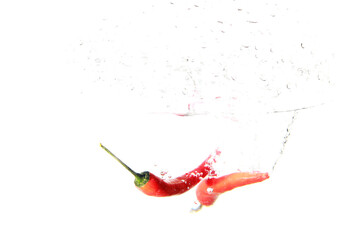 Close up view of red pepper in water with drop splash isolated on white background with copy space