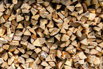 Dry birch firewood stacked for fireplace and stove. Close up view. Wooden background.