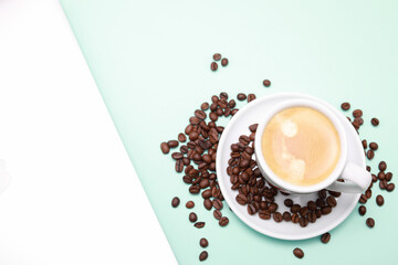 Cup of coffee, beans, and laptop isolated on a light green background.
