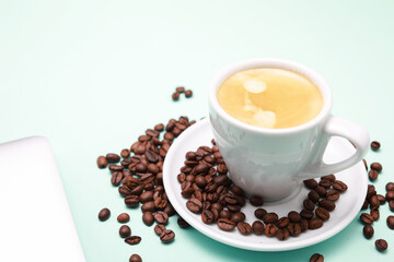 White cup of coffee, around beans, note book and pen isolated color background.