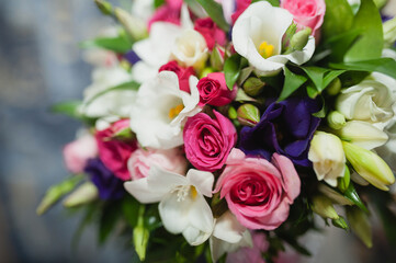 Close-up photo of a bridal bouquet, white, purple and pink flowers.