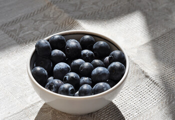 fresh blueberries in a bowl on a 
tablecloth