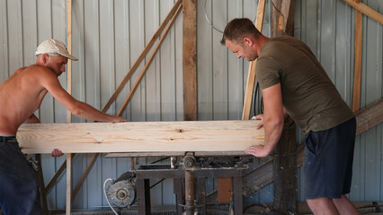 Workers jointing board on old woodworking machine