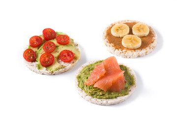 Assortment of ingredients on puffed rice cakes isolated on white background