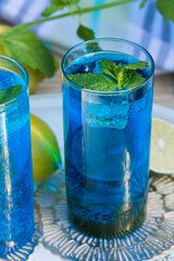 Blue Curacao refreshing drink with lime and lemon slices, garnished with fresh mint leaves.