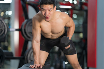 Fototapeta na wymiar Sporty man training with dumbbell in gym