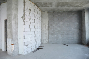 Beginning the renovation of a new apartment with concrete and brick walls in a new residential building.