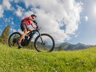 active senior woman riding her electric mountain bike in the Allgau Alps near city of Immenstadt, Algäu, Bavaria, Germany