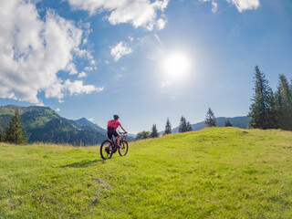 Fototapeta premium active senior woman riding her electric mountain bike in the Allgau Alps near city of Immenstadt, Algäu, Bavaria, Germany