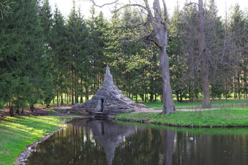 Tuff bridge or Hill made of wild stone, which is reflected in the water of the Catherine Park pond.