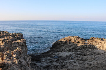 A lifeless stone beach against the blue sea and blue sky. Ayia Napa. Cyprus.