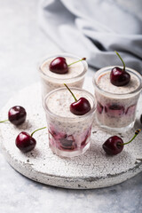 Chia pudding with cherry berries, natural yogurt,  in a glass on a grey surface. Selective focus. Healthy dessert, proper nutrition, super food.
