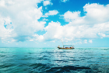 Boat with tourists in ocean in Zanzibar at sunny day