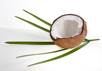 Coconut pieces with palm leaves isolated on a white background.
