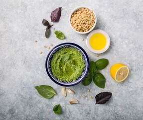 Homemade basil pesto with pine nuts, parmesan and garlic. Green pesto sauce in a bowl, top view