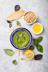 Homemade basil pesto with pine nuts, parmesan and garlic. Green pesto sauce in a bowl, top view