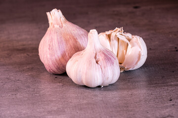 three large heads of pink garlic on a kitchen worktop