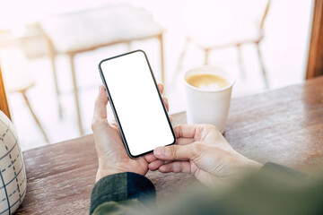 cell phone mockup image blank white screen.woman hand holding texting using mobile on desk at coffee shop.background empty space for advertise.work people contact marketing business,technology