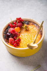 Creme brulee with raspberry  on light  baking sheet. Space for your caption.