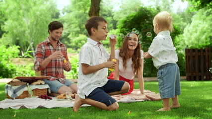 Happy man and woman spending weekend with children in forest