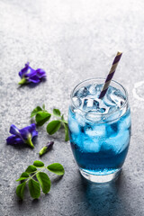 Butterfly pea flower herbal tea for healthy drinking on grey concrete background.
