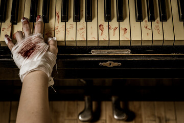 Bandaged and bloody hands of a pianist playing the piano - 365258211