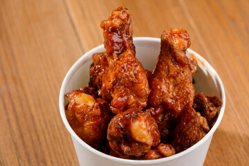 Yummy deep-fried chicken drumsticks on wooden background