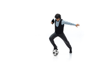 Fototapeta na wymiar Man in office clothes playing football or soccer with ball on white background like professional player. Unusual look for businessman in motion, action kicking ball. Sport, healthy lifestyle