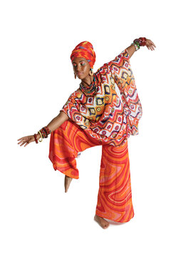 Cute African American woman in traditional clothes dancing in the studio