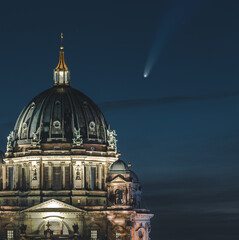 Neowise Comet visible in city of Berlin over Berlin Cathedral with illuminated night sky. Astro...