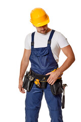 Young caucasian repairman worker in yellow helmet and uniform. handyman wearing tool belt isolated on white studio background