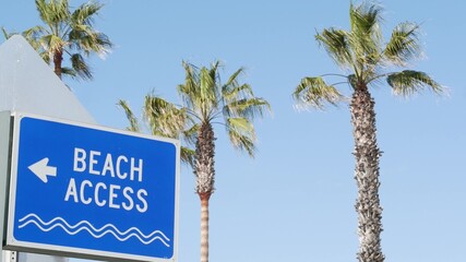 Beach sign and palms in sunny California, USA. Palm trees and seaside signpost. Oceanside pacific...