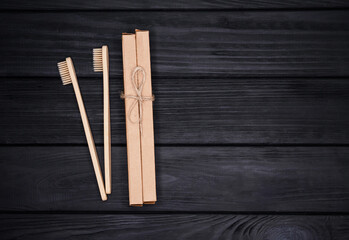 Group of eco-friendly bamboo toothbrushes on wooden black background